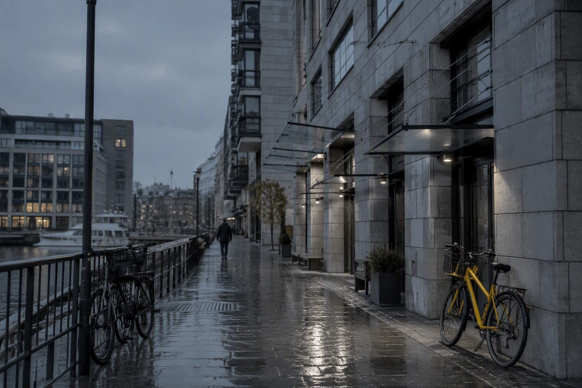A desaturated waterfront street retains architectural detail and one restrained yellow bicycle accent.